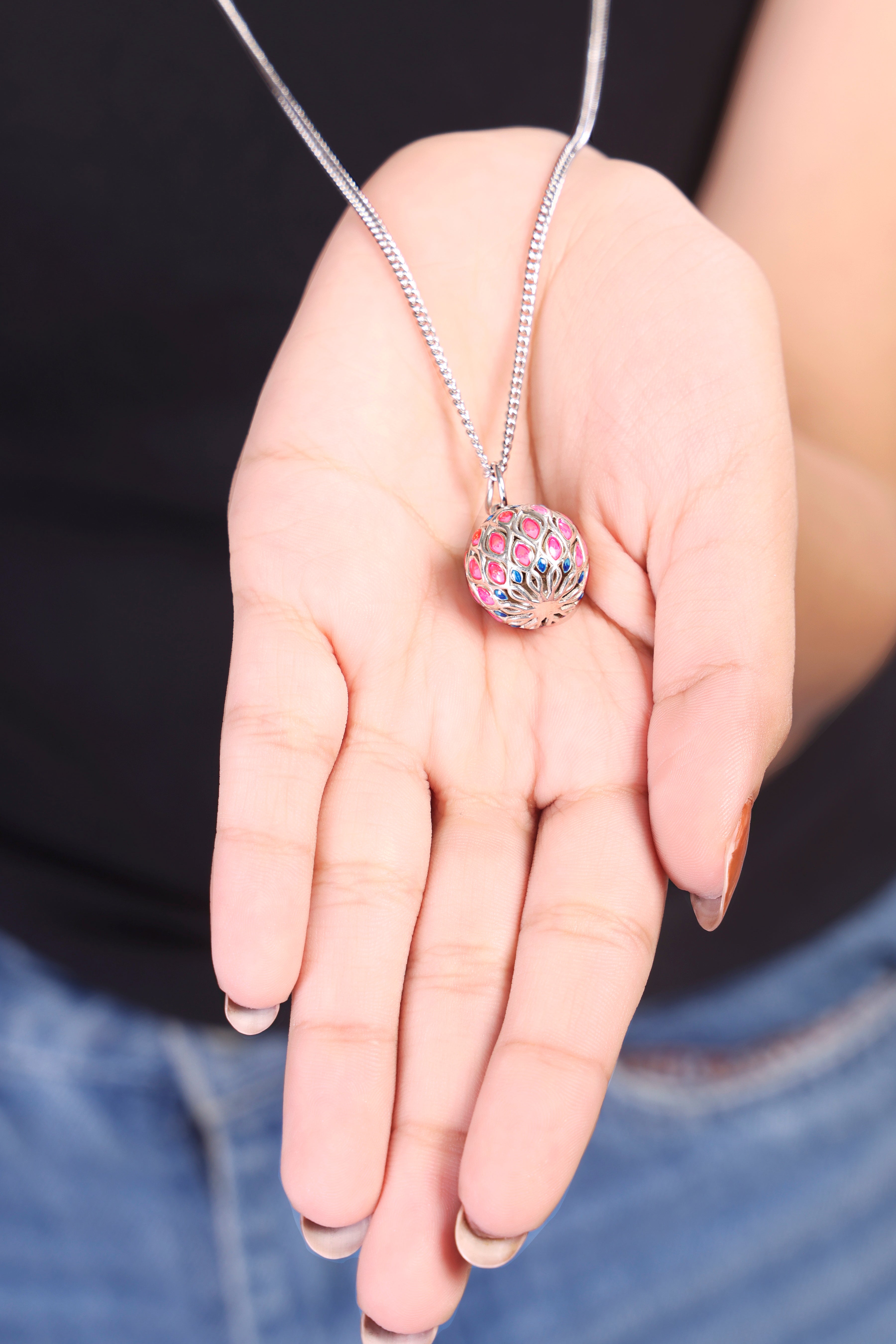 A 925 silver harmony ball bola necklace resting on a baby bump, showcasing the soothing chime pendant for mothers.