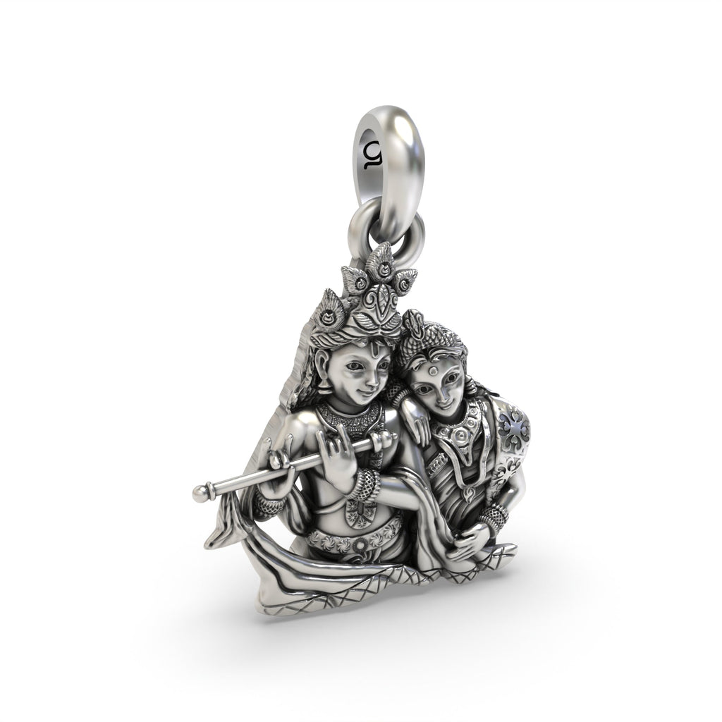 The oxidized 925 sterling silver Radha Krishna pendant shown from an angled perspective to display its craftsmanship.