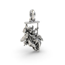 The complete Radha Krishna on a swing silver pendant shown from a top-down angle to display its full form and texture.