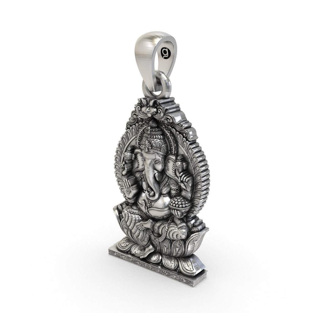 A close-up of the handmade sterling silver Ganesha pendant held in hand to show its size and detailed oxidized texture.
