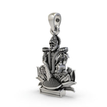 The sterling silver Lakshmi Maa pendant shown for size reference, a perfect spiritual keepsake for prosperity.