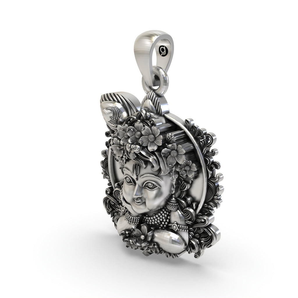 The sterling silver Bal Krishna face pendant shown with an oxidized finish to emphasize its divine details.