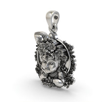 The sterling silver Bal Krishna face pendant shown with an oxidized finish to emphasize its divine details.