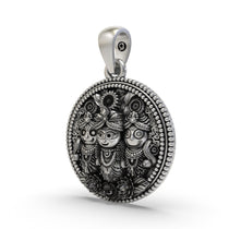 Close-up detailing the carved trio of Lord Jagannath on this sterling silver medallion.