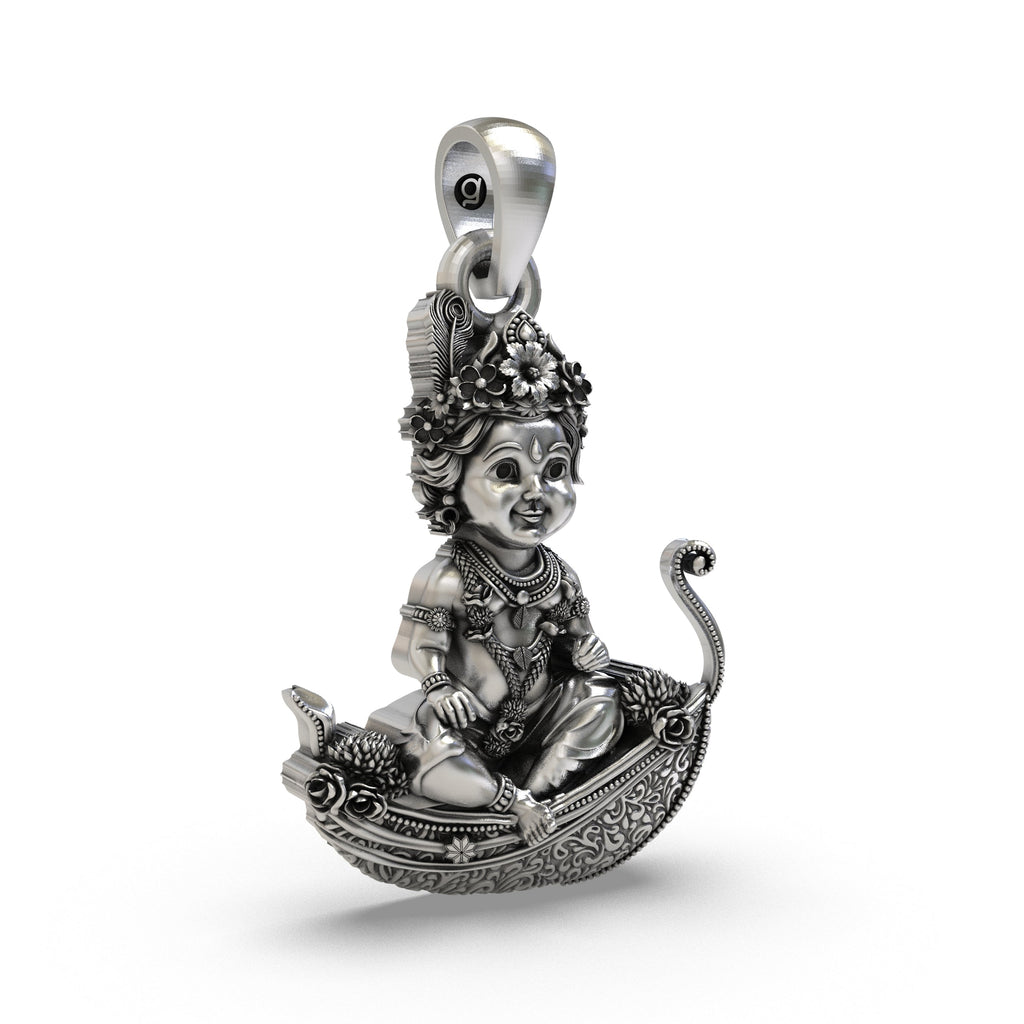Angled view highlighting the oxidized depth and intricate carvings of the silver baby Krishna pendant.