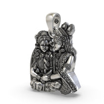 Close-up detailing of the handcrafted silver Radha Krishna pendant showing floral crown and jewels.