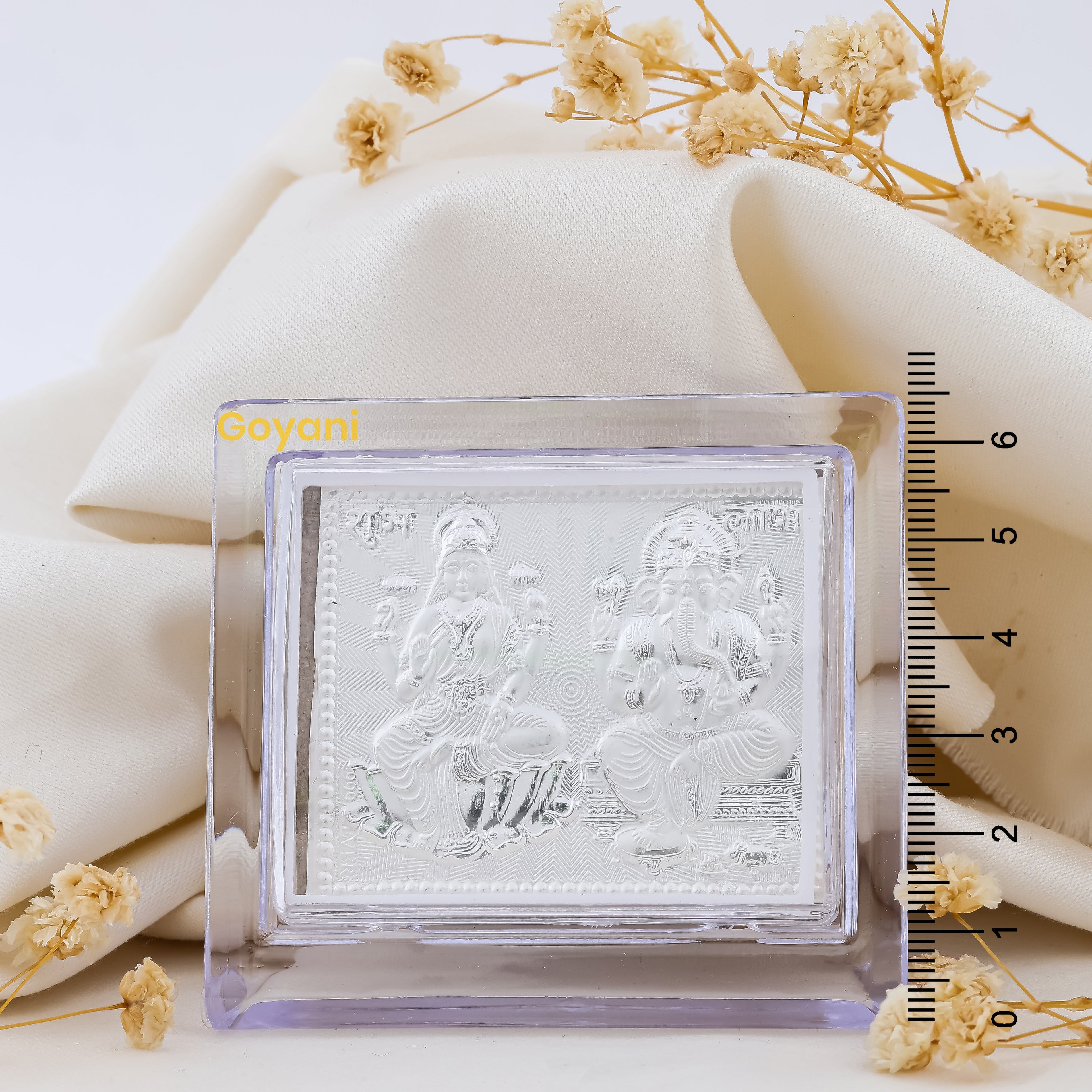 A close-up of the high-polished 999 silver Ganesha Lakshmi stand, showing the divine figures' details.
