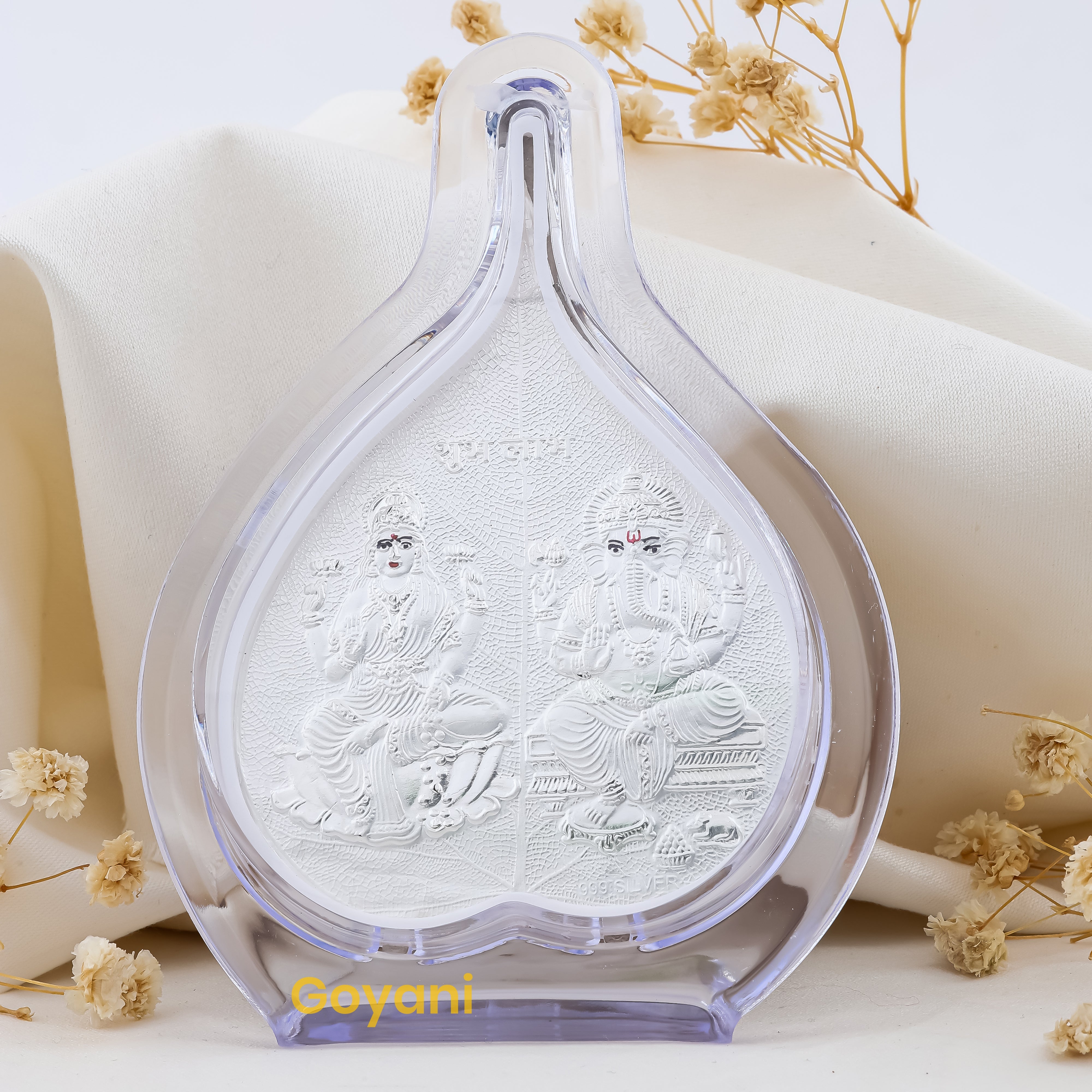 Front view of the 999 pure silver Ganesha and Lakshmi Maa idol seated on an intricately designed pan leaf stand. Main image