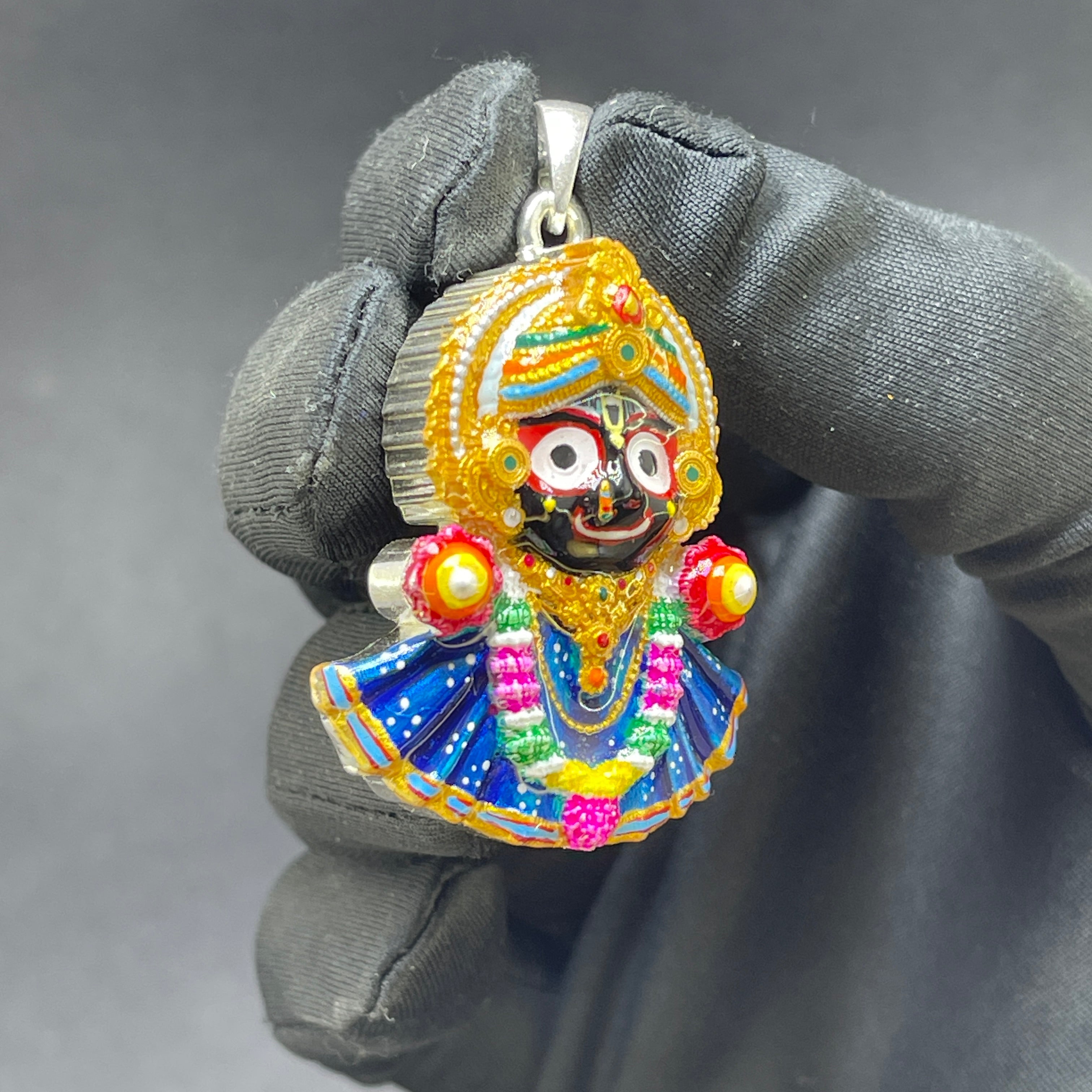 Close-up detail of the intricate Meenakari enamel on the 925 silver Jagannath pendant's iconic eyes.