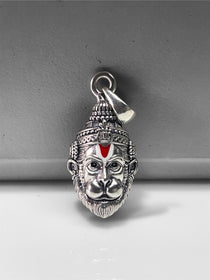 The 925 oxidised silver Hanumanji face pendant held in hand to show its 25mm size and intricate design details.