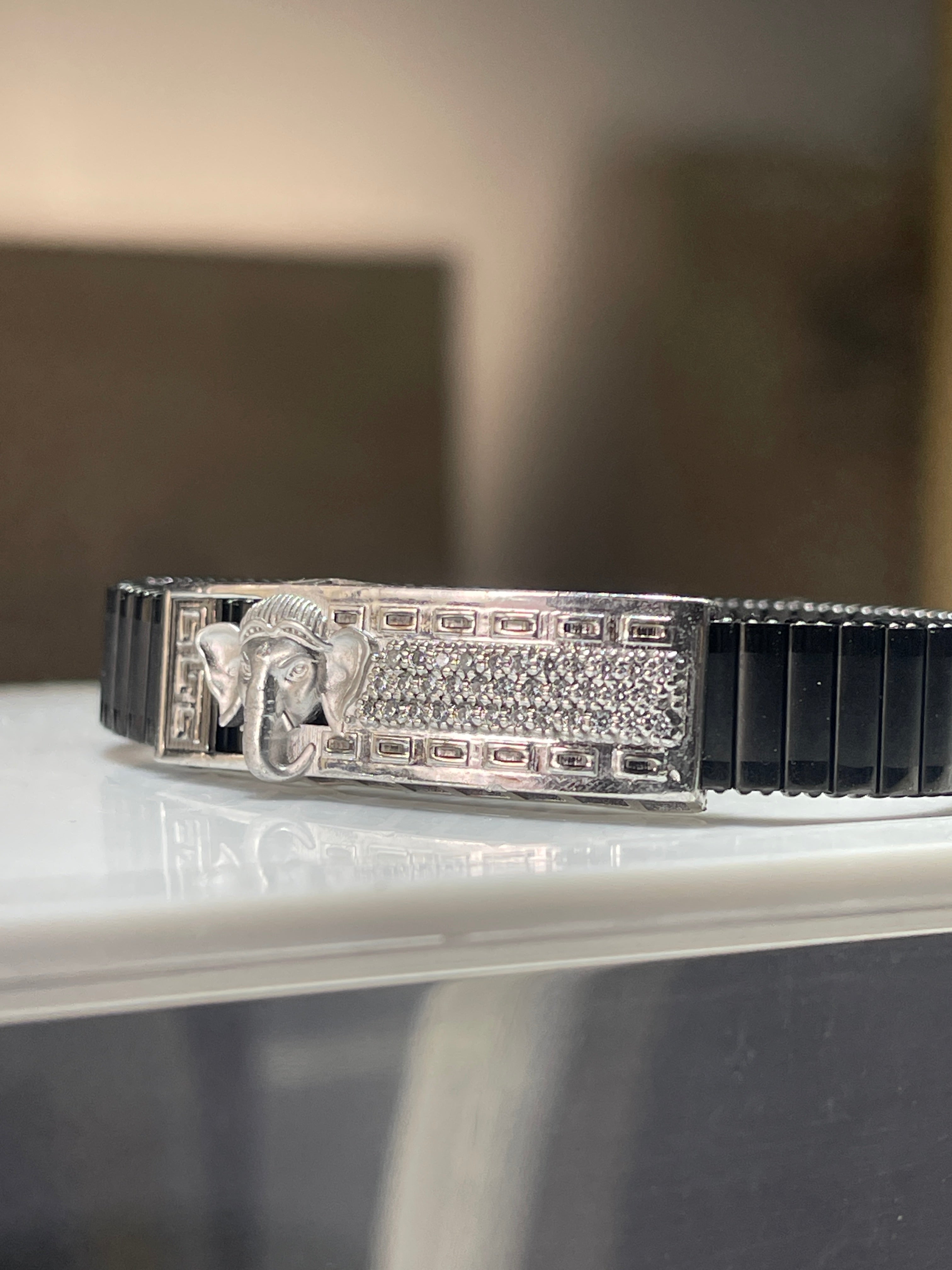 Side profile of the 925 silver Lord Ganesha bracelet for men, displaying the sleek black stainless steel spring belt.