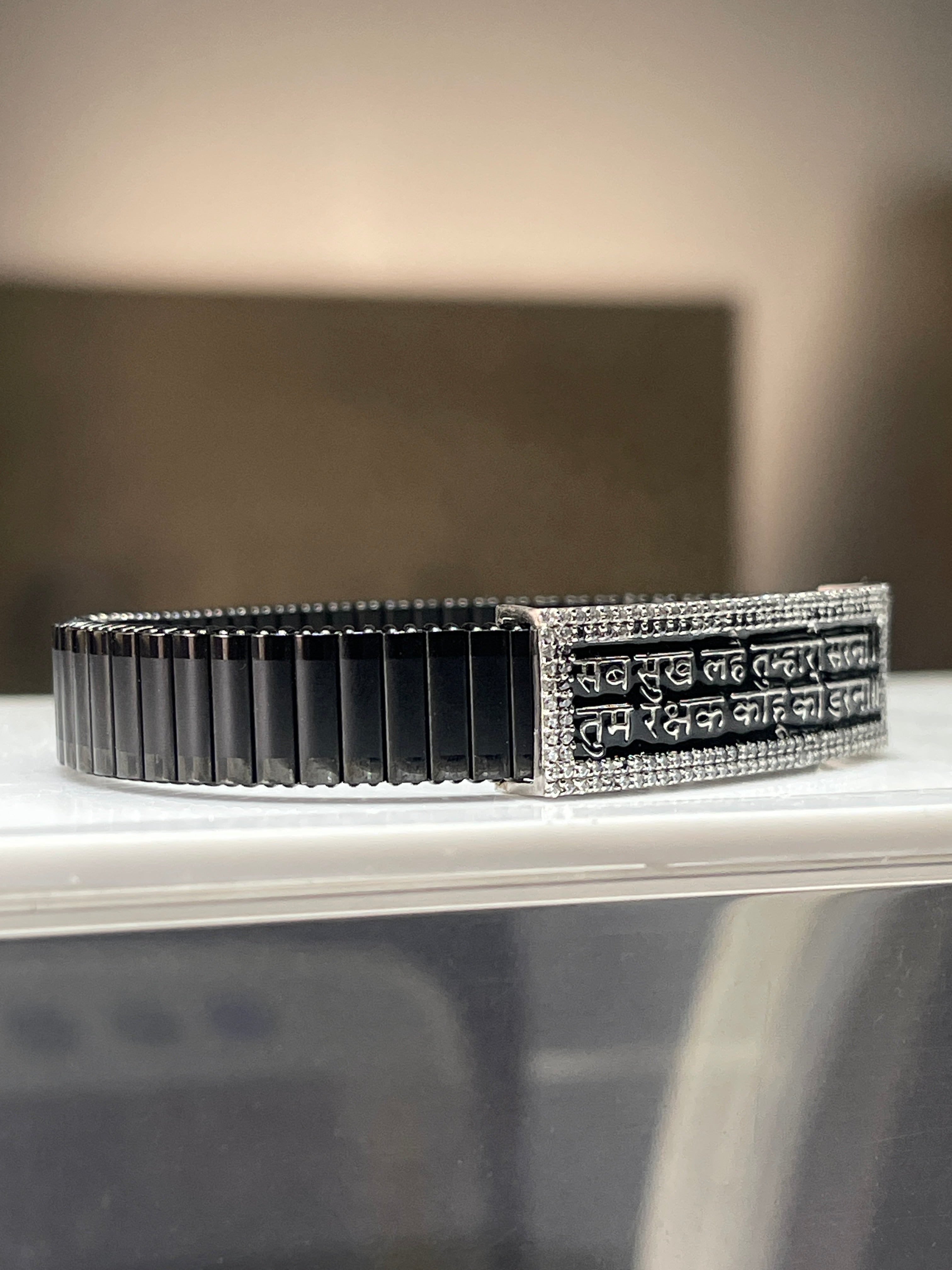 Angled view of the Hanuman Chalisa Kada, highlighting the sterling silver plate with its CZ diamond border.