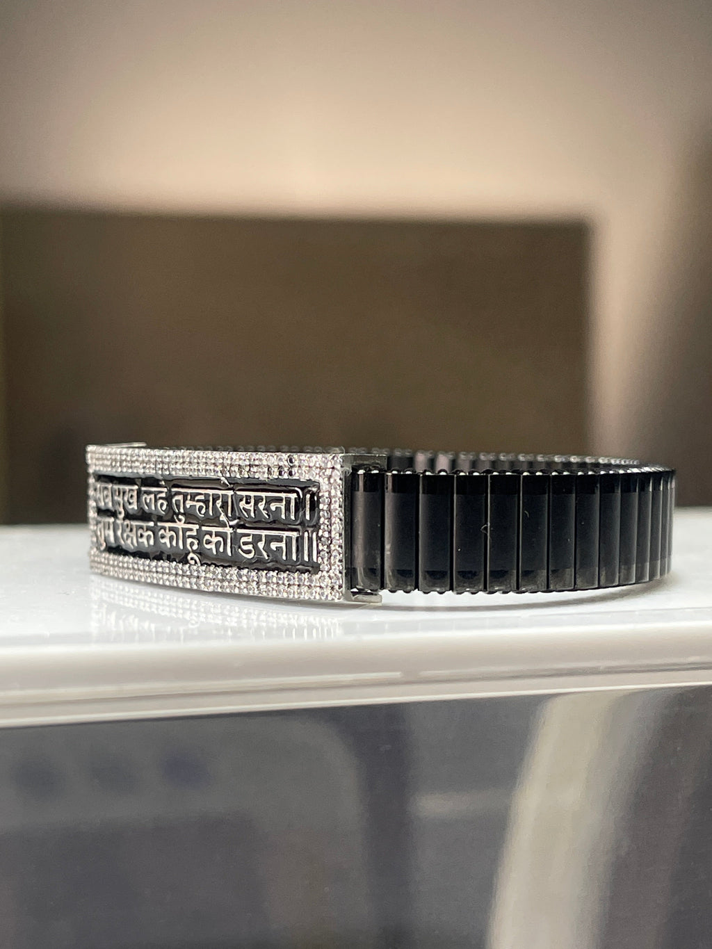 Close-up detail of the Hindi mantra engraving on the 925 silver centerpiece of the men's spiritual bracelet.