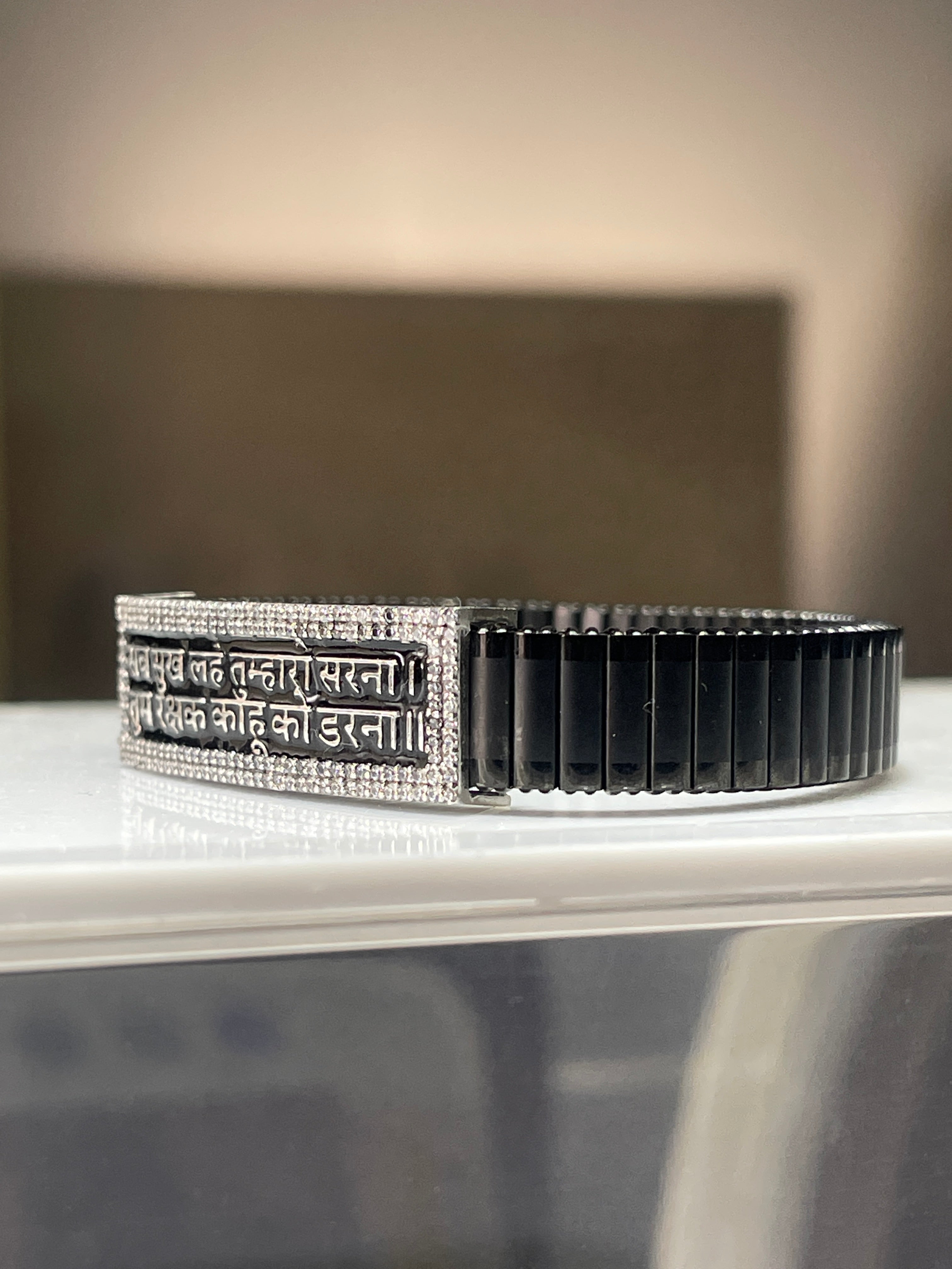 Close-up detail of the Hindi mantra engraving on the 925 silver centerpiece of the men's spiritual bracelet.