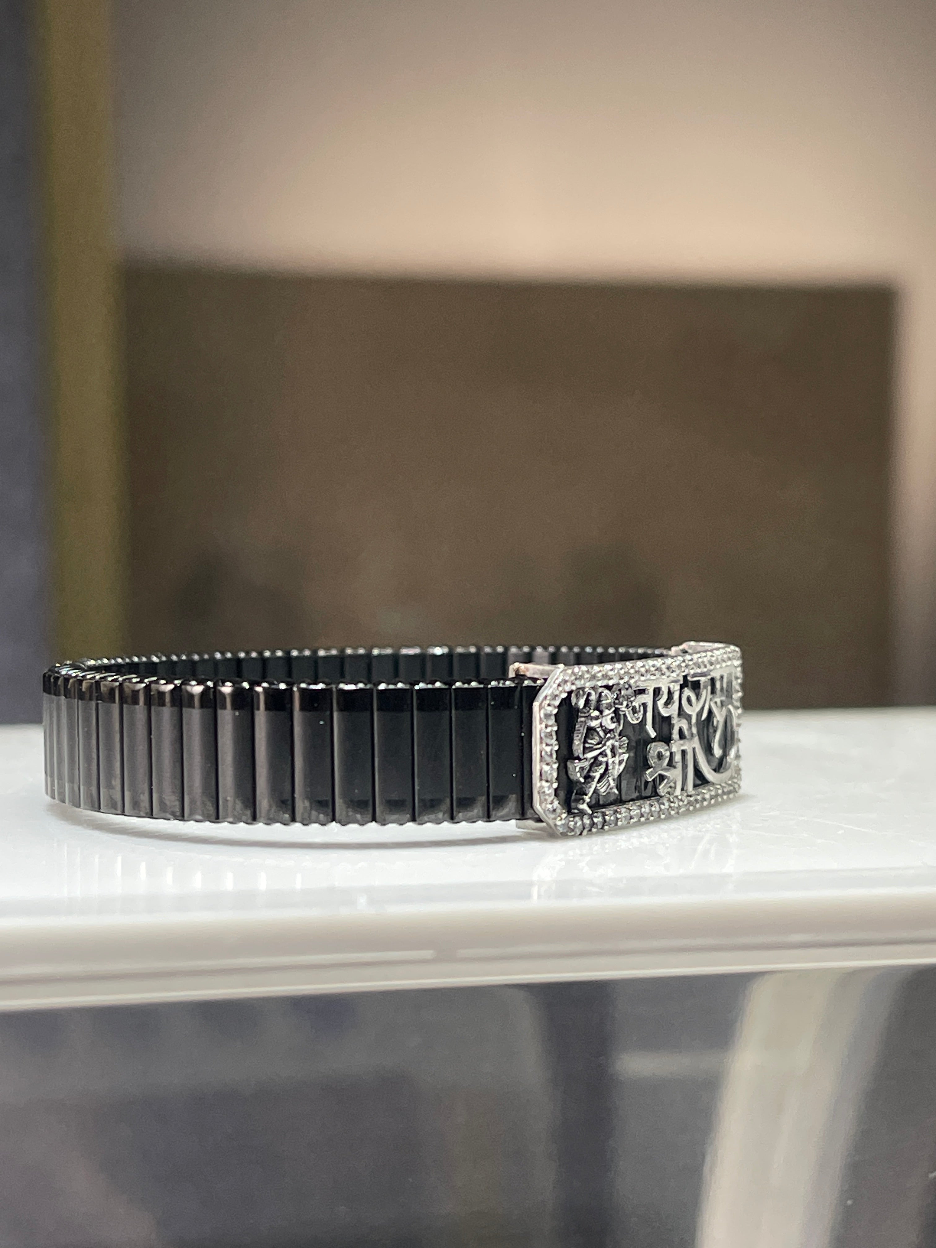 Detailed close-up of the intricate Hanuman Ji figure on the sterling silver spiritual kada bracelet for men.
