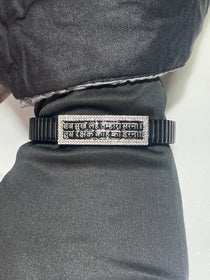 The complete Hanuman Chalisa bracelet showing the flexible black stainless steel strap and silver mantra plate.