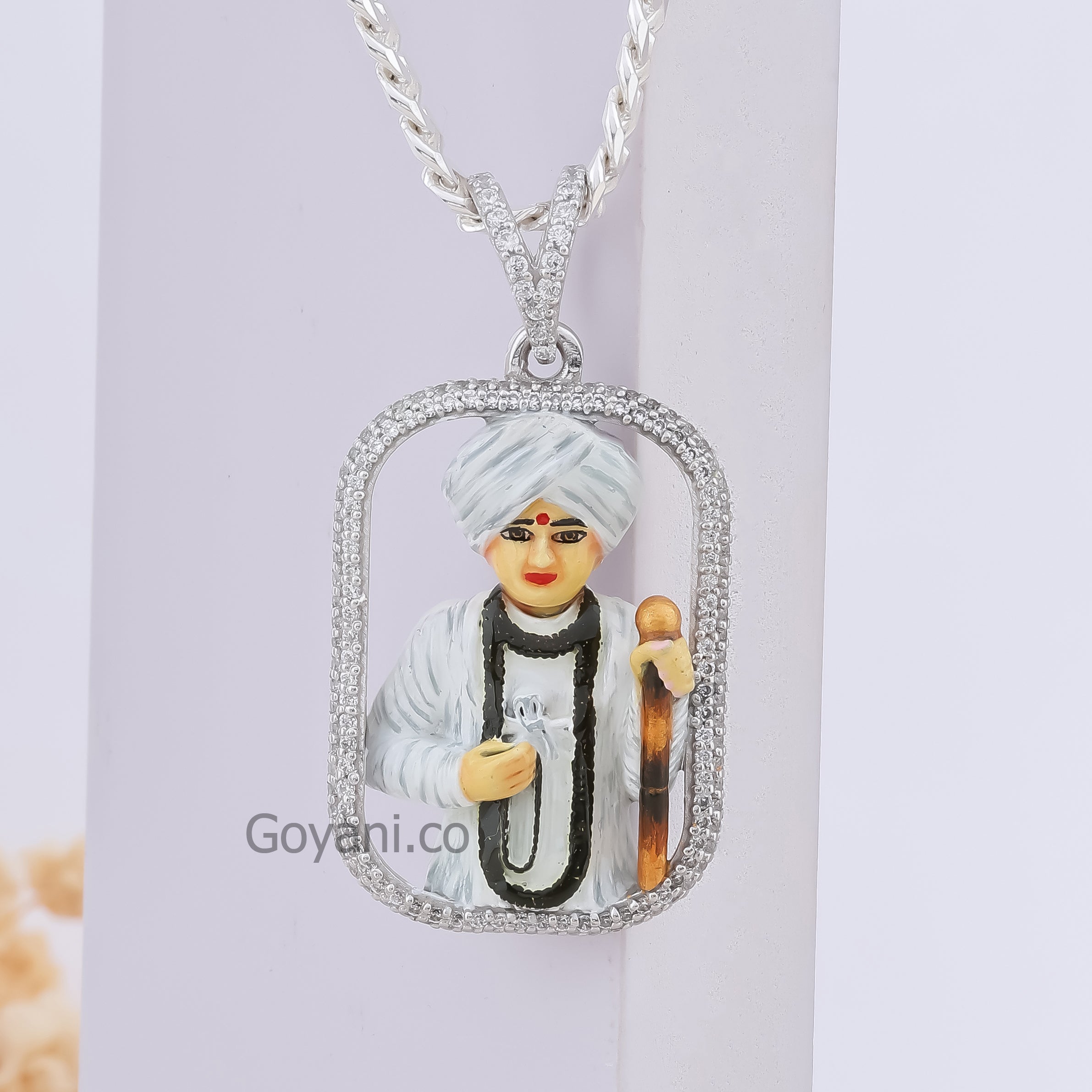 Close-up of the Jalaram Bapa silver pendant highlighting the detailed enamel craftsmanship and sparkling diamonds.