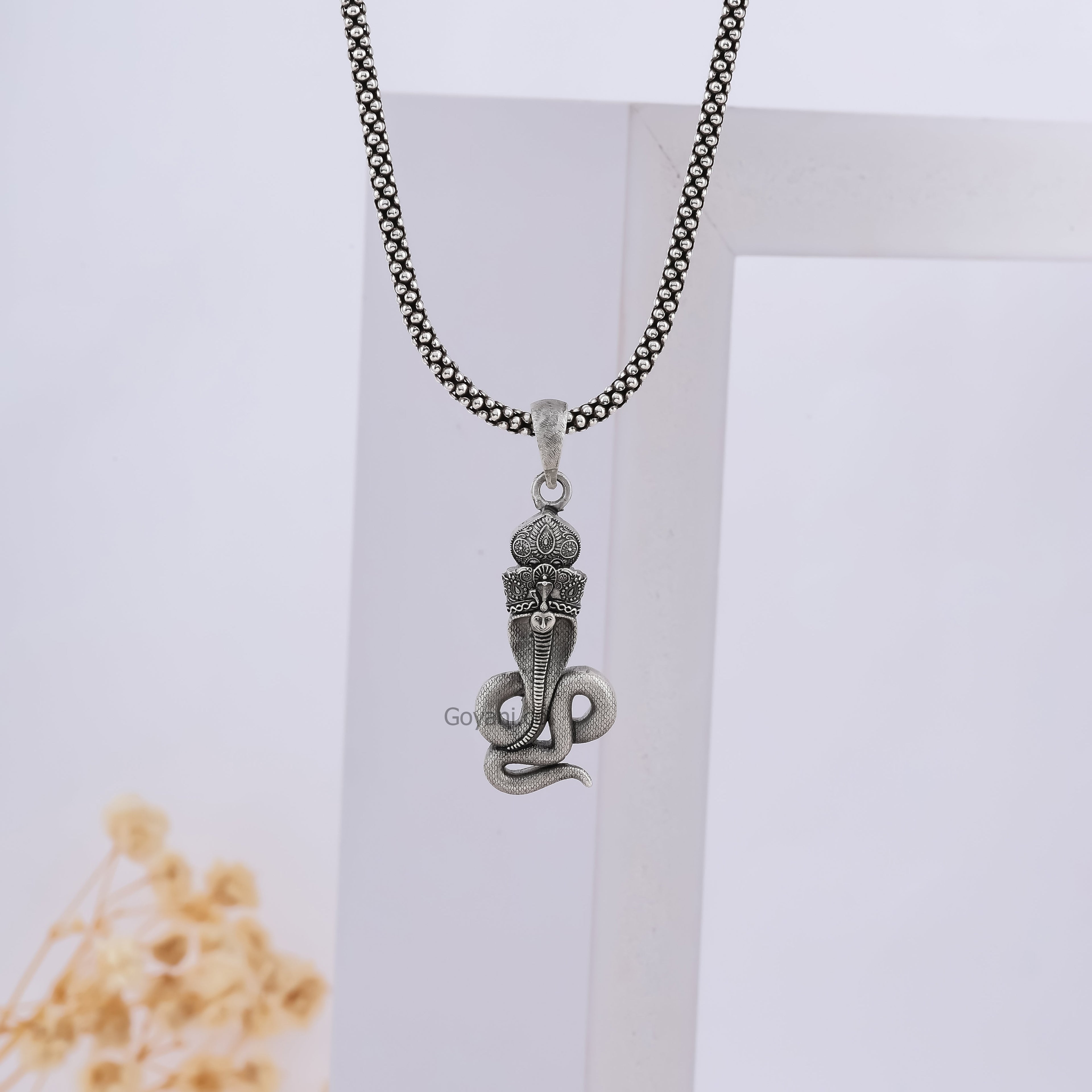 A person wearing the 925 sterling silver Goga Maharaj pendant to demonstrate its size as a piece of spiritual jewelry.