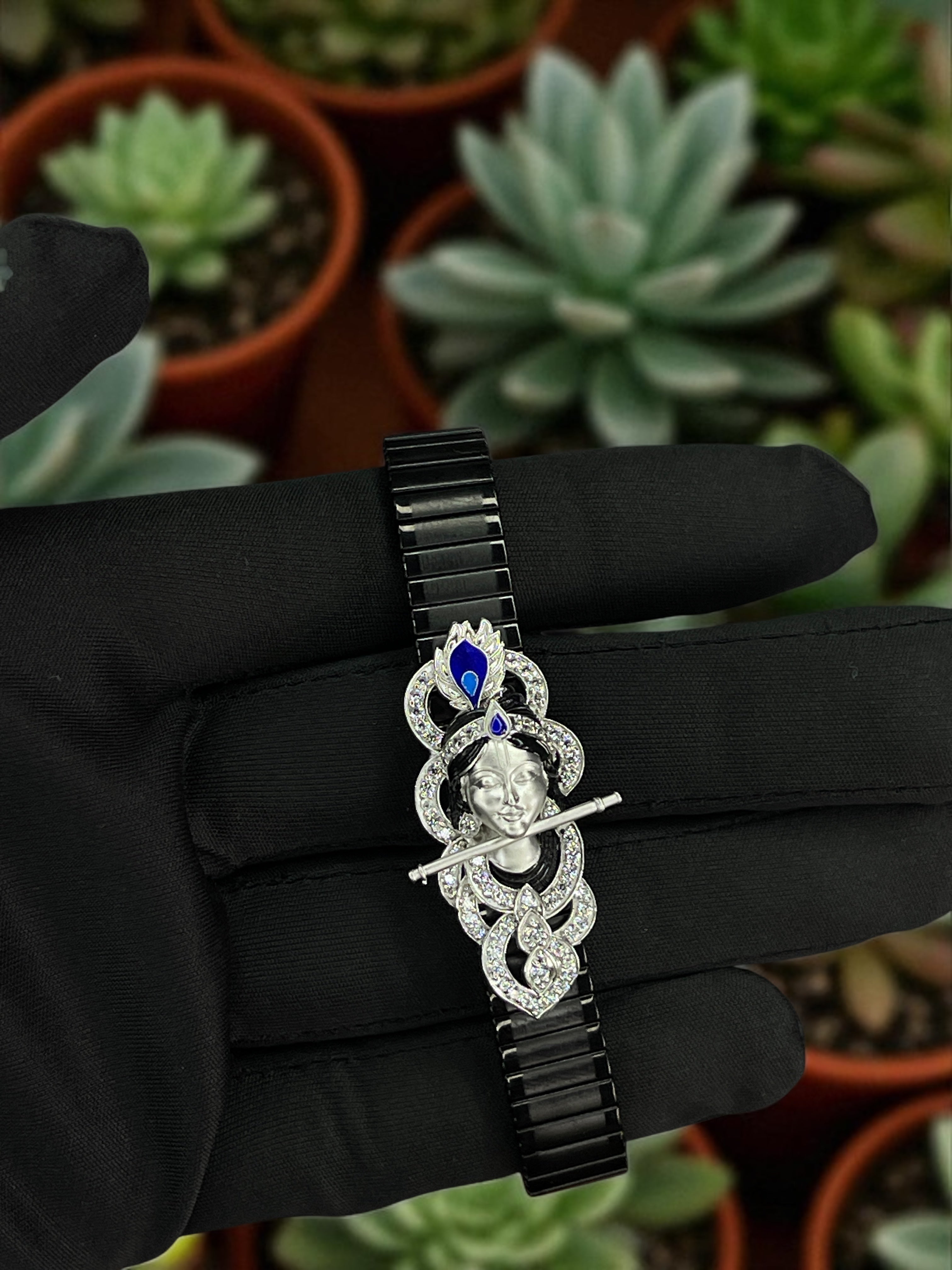 A detailed close-up of the 925 Silver Krishna Bracelet, showcasing the intricate enamel and stone work on the deity.
