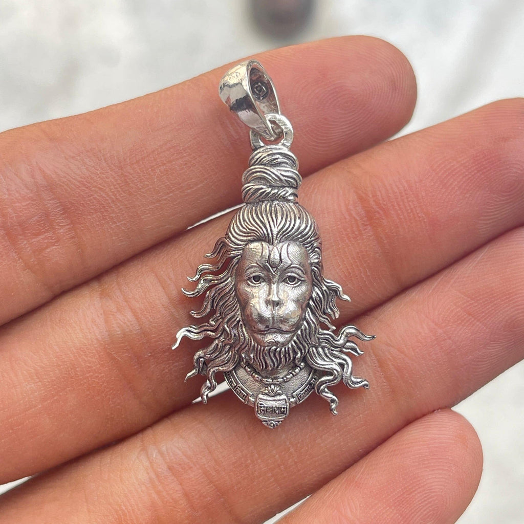 Handheld view of the 925 Silver Hanumanji Face Pendant, demonstrating its scale and the rich detail of the oxidized silver.