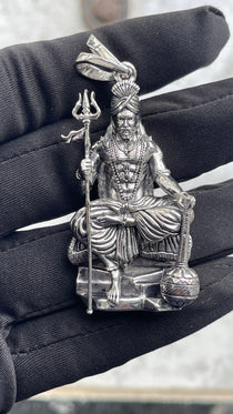 A model wearing the oxidized 925 silver Muniswarar locket to demonstrate its size and appearance against the neck.