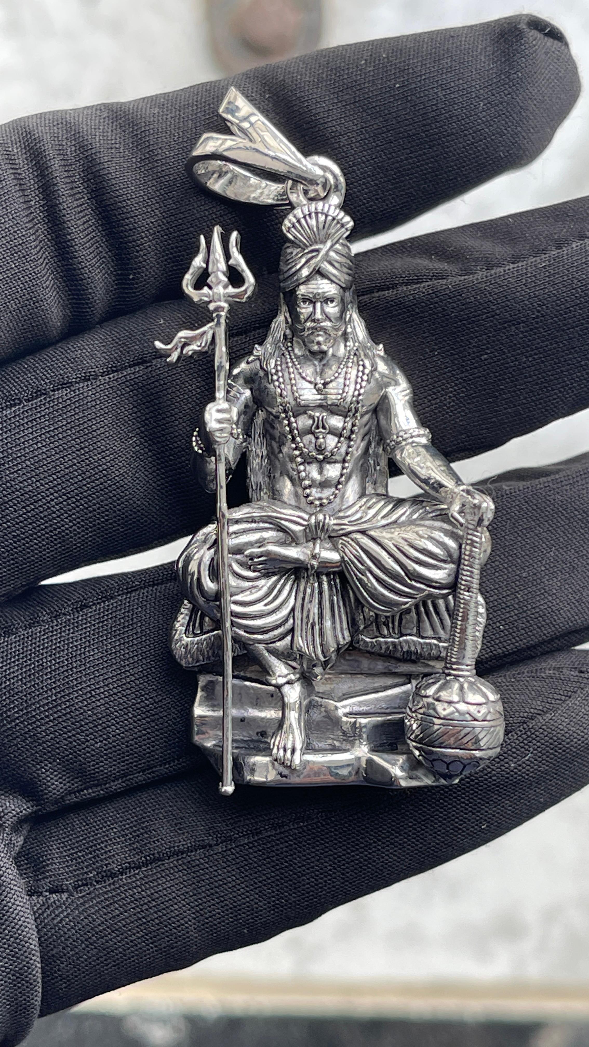 A model wearing the oxidized 925 silver Muniswarar locket to demonstrate its size and appearance against the neck.
