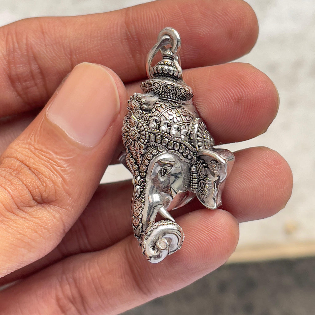 The lightweight 925 Silver Ganpati Face Pendant held to demonstrate its 1.5-inch scale and polished oxidized shine.